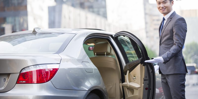 Chinese chauffeur opening car door Chinese chauffeur opening car door